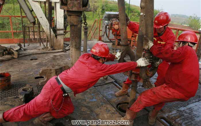 عکسی از کسب روزی حلال؛ کارگرانی که در حال محکم کردن و بستن لوله ها بر روی چاه نفت و میعانات گازی هستند