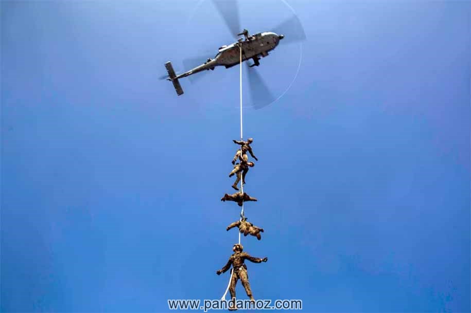 عکس آویزان شدن تعدادی سرباز یک طناب آویزان از یک هلیکوپتر (بالگرد)