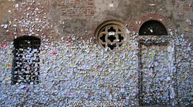 عکس دیواری قدیمی در رم ایتالیا که مردم و افراد عاشق با یادداشتها و نوشته هایی با عنوان دوستت دارم روی دیوار. در تصویر کاغذهای کوچک رنگارنگ به دیوار چسبانیده شده