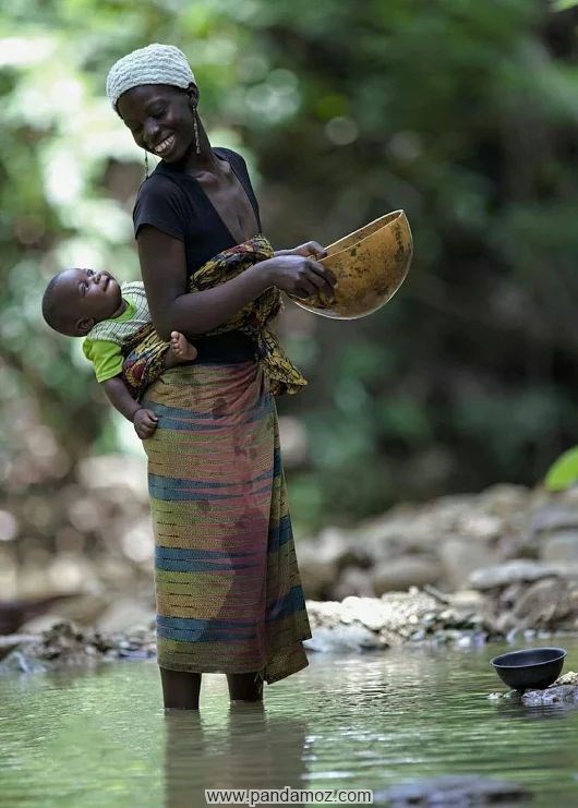 عکس مادر در رودخانه و کودک بسته شده بر پشت مادر