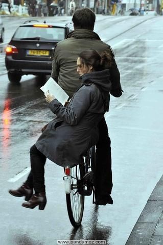 عکس دختر در حال مطالعه که بر ترک دوچرخه سواری نشسته