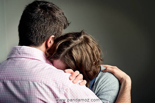 عکس زنی گریان که سرش را روی شانه مردی گذاشته و در حال گریه کردن است