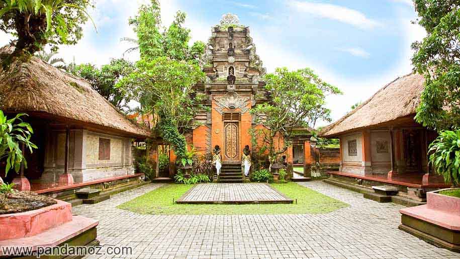 عکس بسیار زیبا از چزیره بالی در اندونزی. تصویر محوطه ایی از ساختمانهای زیبا و رنگارنگ با سقف های شیب دار پوشالی و درختان سرسبز در عکس دیده می شوند