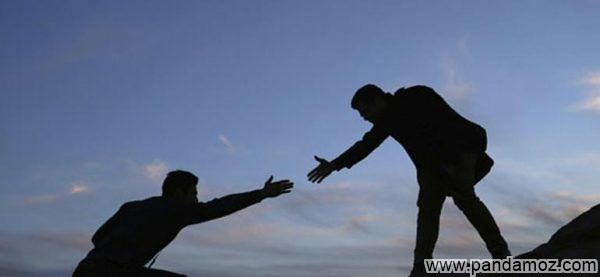 عکس کمک به مردم و دست کسی را گرفتن. در تصویر مردی در بالا دست دراز کرده و دست فرد دیگری را در پایین می خواهد بگیرد