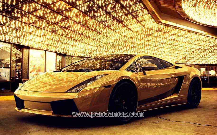 عکس ماشین و اتومبیل طلایی با روکش طلا که رنگ زرد طلایی آن در نور چراغها می درخشد. در تصویر نور چراغ های زرد همه سالن را پر کرده است