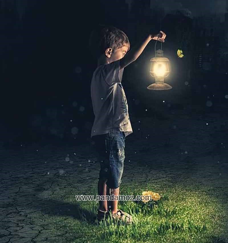 عکس پسر بچه در شب با فانوس روشن در دست. در تصویر پسرک فانوس را بالا گرفته و پروانه یا شاپرکی را نگاه می کند. زیر پایش چمن سبر زنگ و گلی دیده می شود