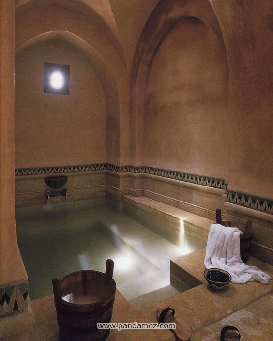 عکس حمام تاریخی از آثار دوران قدیم و خزینه حمام. در تصویر کاسه ، سطل (دلو) چوبی و دمپایی یا کفش چوبی مخصوص حمامهای زمانهای قدیم دیده می شود