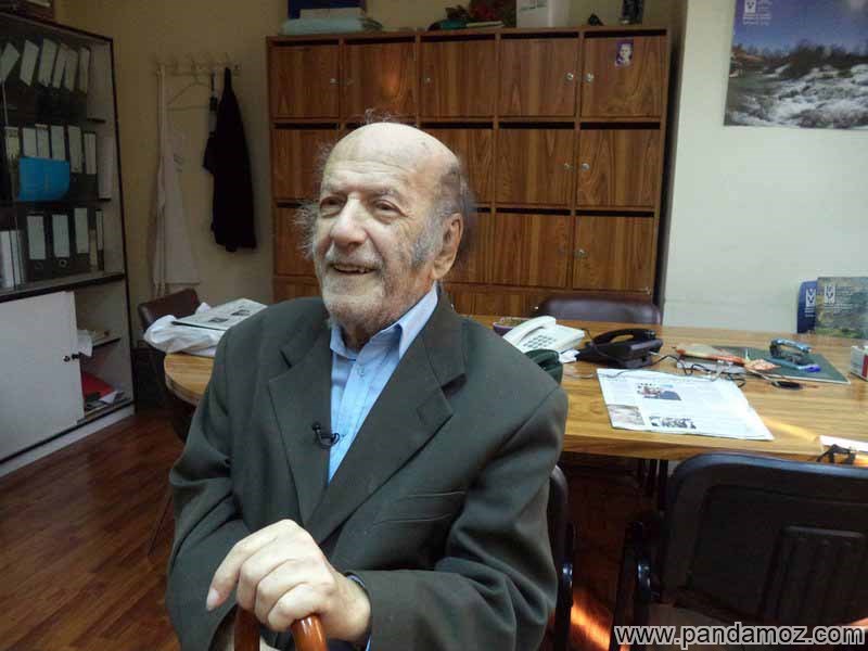 عکس جرج جرداق مسیحی لبنانی در دفتر کار. در تصویر او روی صندلی نشسته و عصایی در دست دارد و پشت سرش میزکار دیده می شود