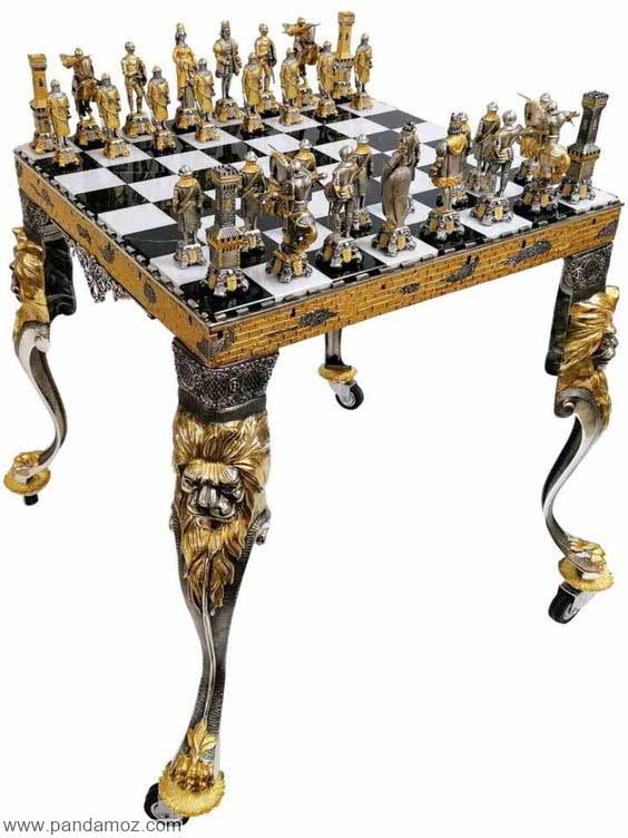 عکس یک شطرنج قدیمی تاریخی روی میز بسیار زیبا و برنزی که مهره های شطرنج به شکل مجسمه های کوچک برنزی آدم، اسب، قلعه، پادشاه و غیره است