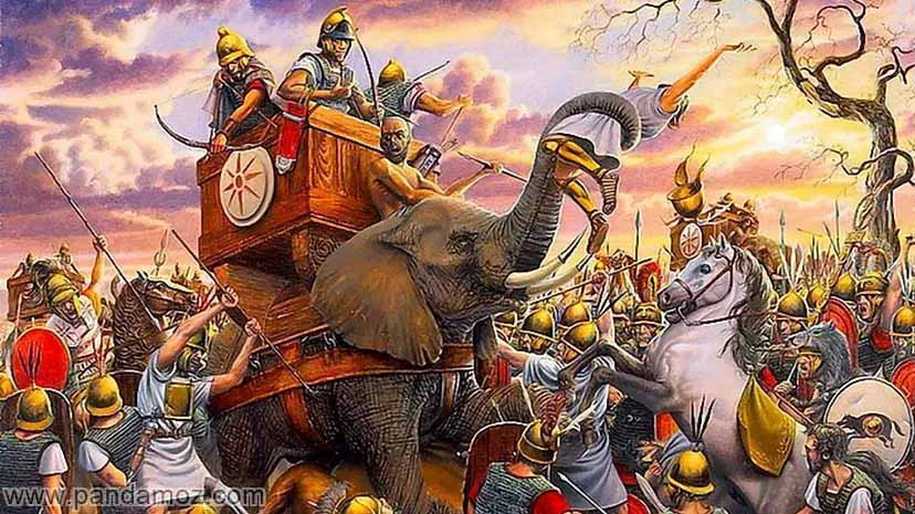 عکس نقاشی تابلو میدان نبرد با حضور فیل جنگی و اسب و مردان جنگاور و سربازان در تصویر تعدادی سرباز بر روی صندوقی روی فیل سوار هستند و سربازان دارای کلاهخود و نیزه به دست دیده می شوند