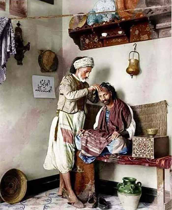 عکس تابلو نقاشی مربوط به زمانهای قدیمی و مغازه آرایشگاه دوران کهن. در تصویر مردی روی تخت نشسته و استاد سلمانی ایستاده در حال کوتاه کردن موی سر مشتری است