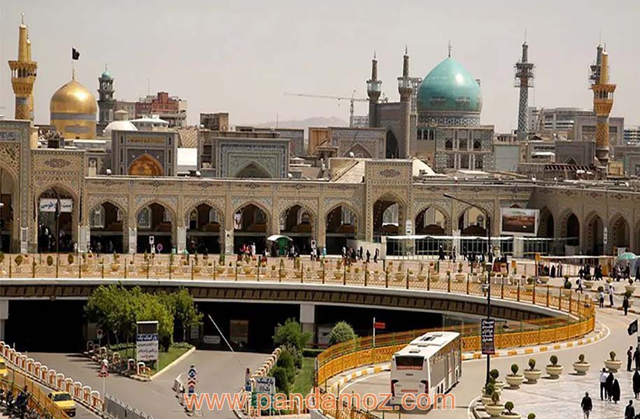 عکس بارگاه امام رضا(ع) از خیابان مقابل حرم. در تصویر دو گنبد دیده می شود: گنبد طلایی امام رضا(ع) و گلدسته های آن و نیز گنبد به رنگ آبی فیروزه ایی مسجد گوهرشاد مشهد